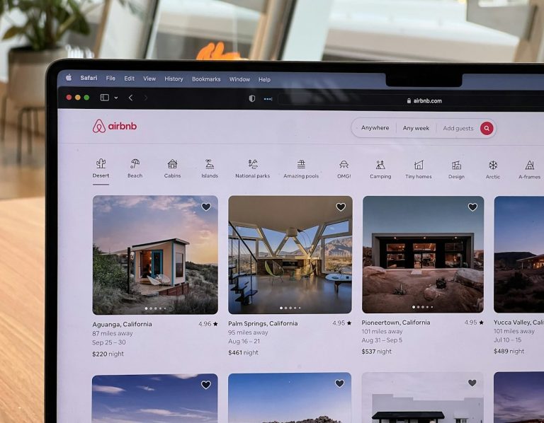 Airbnb & serviced accommodation management. Laptop screen displaying a grid of properties
